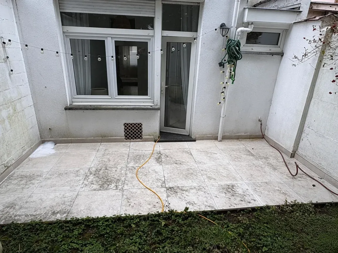 Terrasse carrelée noircie avant nettoyage à Overijse